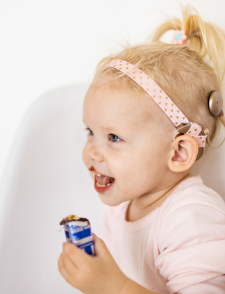 Glückliches kleines Mädchen mit einem Cochlea Implantat.